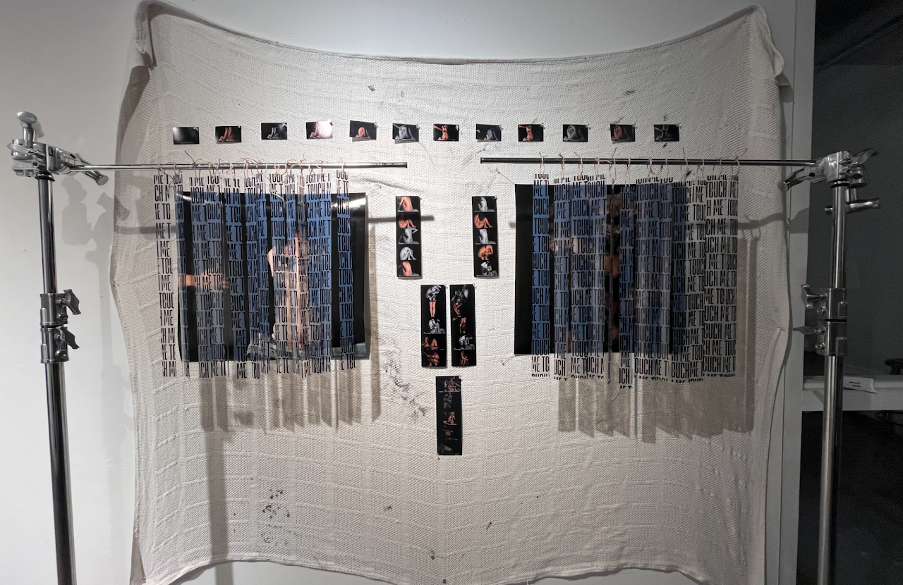 Physical art installation with hanging printed strips and photographs