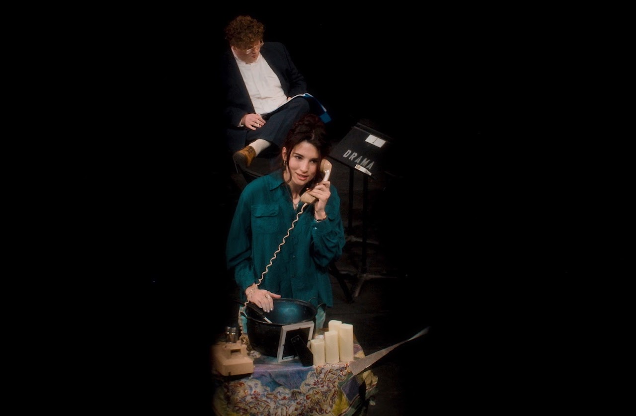 Stage scene with a performer holding a phone