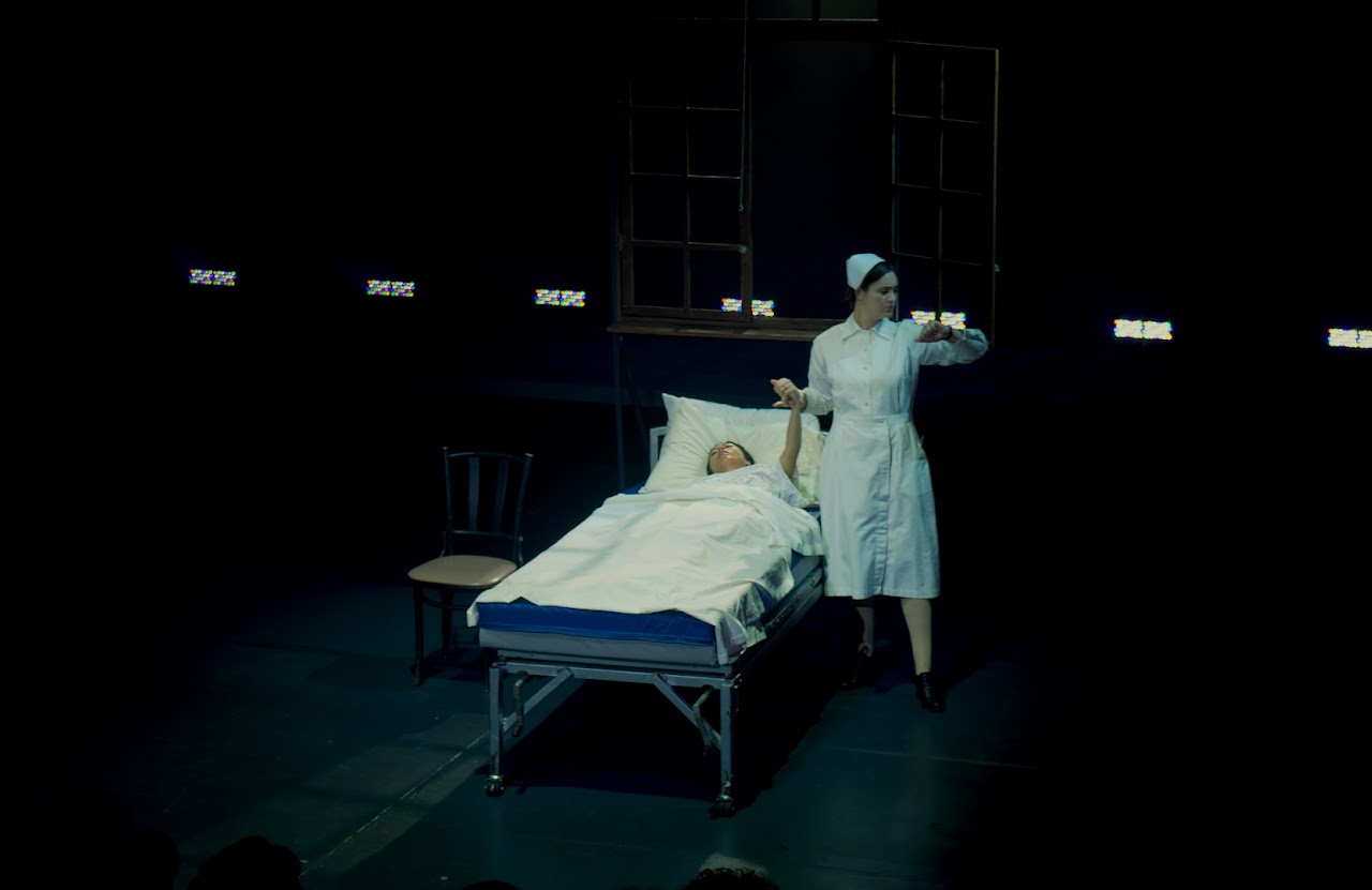 Recorded theater scene with hospital bed and nurse